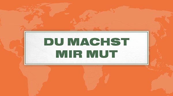 Auf einem orangenen Hintergrund steht ein Schild mit dem Titel in grün: Du machst mir Mut