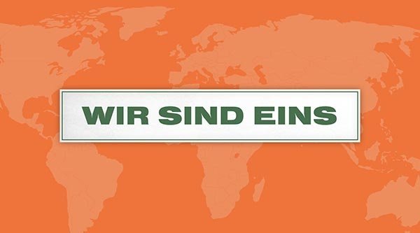 Auf einem orangenen Hintergrund steht ein Schild mit dem Titel in grün: Wir sind eins