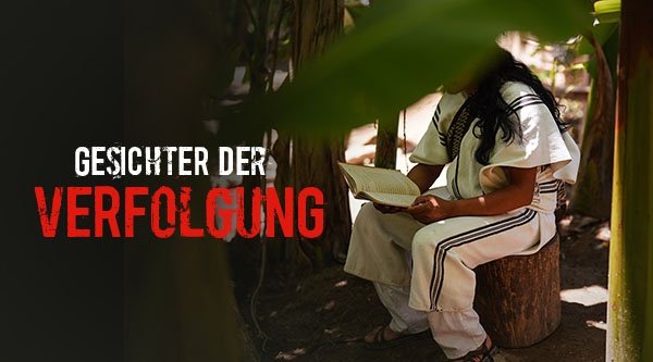 Eine Person sitzt in einem weißer Kleidung auf einem Baumstamm