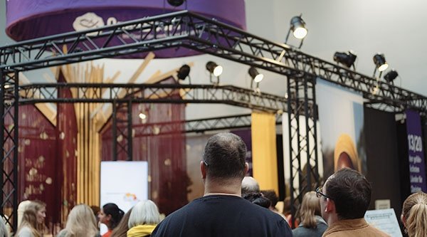 Eine Menschenmenge steht an einem Messestand