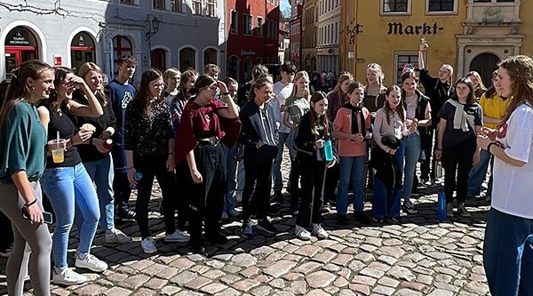 Eine Jugendgruppe steht im Halbkreis auf einem Marktplatz
