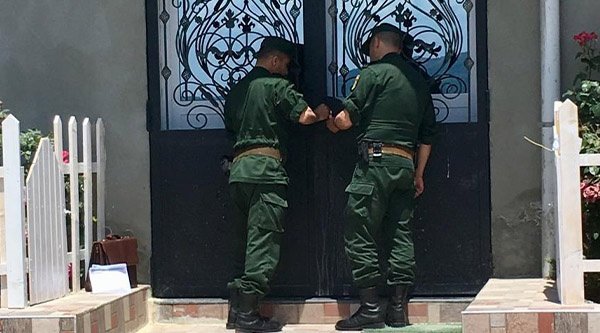 Männer mit grüner Uniform schließen die Tür einer Kirche