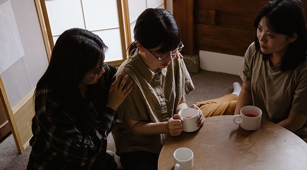 Nordkoreanische Christinnen beten gemeinsam für eine Frau