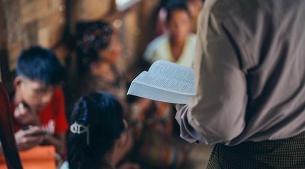 Rücken eines Mannes mit einer Bibel im Arm