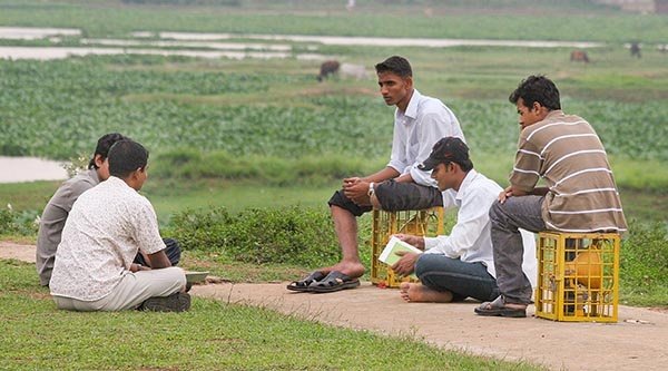 Männer sitzen auf dem Boden in einem Feld
