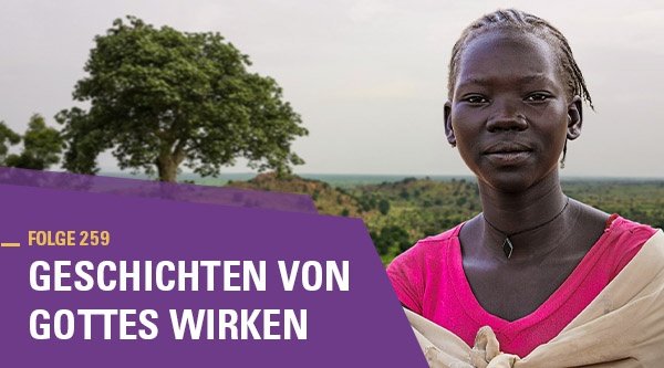 Eine afrikanische Frau steht vor einer grünen Landschaft
