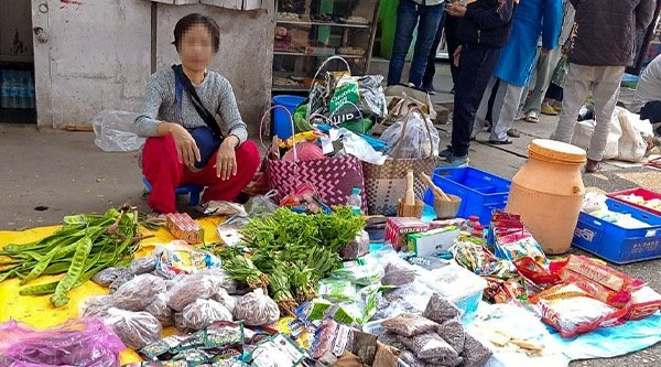 Eine Frau hockt auf dem Boden und ist umgeben von Lebensmitteln