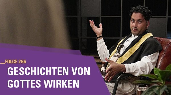 Ein Mann sitzt in einem Sessel und wird interviewt.