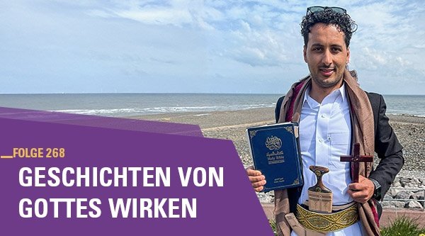 Ein Mann steht mit seiner Bibel und einem Kreuz in der Hand am Strand.