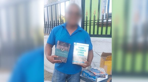 Ein Mann mit blauem Hemd hält Schulungsmaterial in beiden Händen.