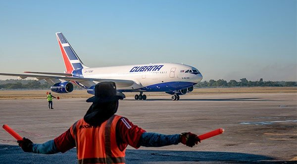 Ein Mann steht am Flughafen und zeigt einem Flugzeug den Weg