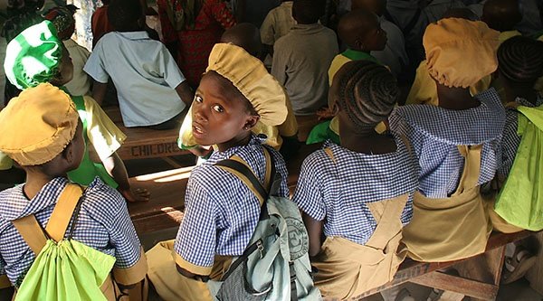 Schülerinnen sitzen auf Schulbänken
