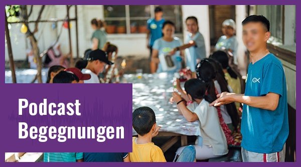 Einige Menschen sitzen gemeinsam an einem Tisch