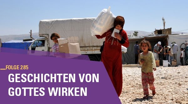 Drei Mädchen laufen auf einer Straße und tragen Kisten und Säcke