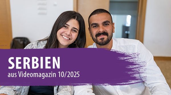 Ein Paar schaut lächelnd in die Kamera