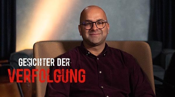 Gesichter der Verfolgung. Ein Mann sitzt auf einem Sessel in einem Raum.