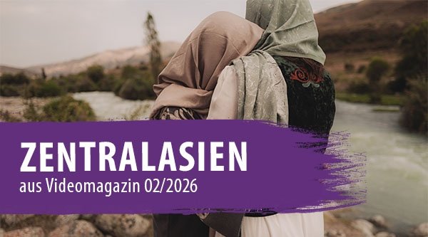 Zwei Frauen stehen an einem Fluss und umarmen sich