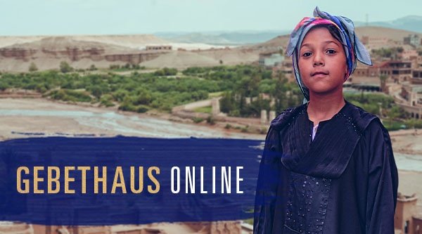 Eine Frau steht in einer Wüste vor einem Dorf