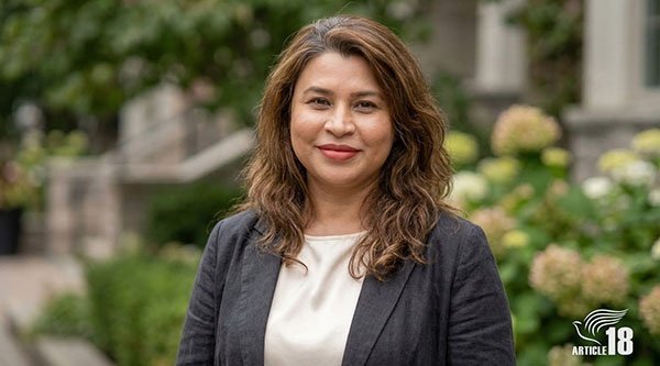 Eine Frau mit braunen Haaren schaut in die Kamera