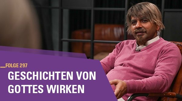 Ein Mann sitzt auf einem Sessel und gestikuliert