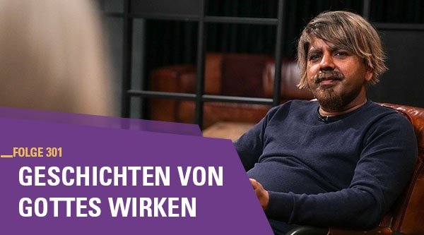 Ein Mann sitzt auf einem Sessel und erzählt etwas