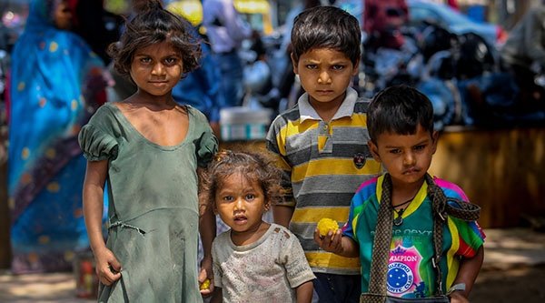 Vier Kinder stehen dicht beieinander und schauen in die Kamera