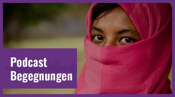 Eine verschleierte Frau blickt in die Kamera