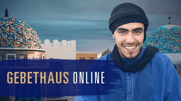 Ein Mann vor einer Moschee lächelt in die Kamera