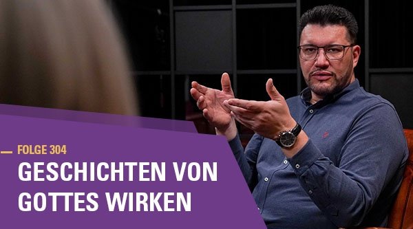 Ein Mann sitzt auf einem Sessel und gestikuliert