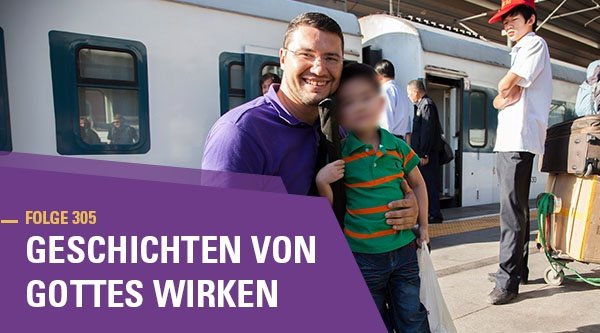 Ein Mann umarmt einen kleinen Jungen am Bahnhof