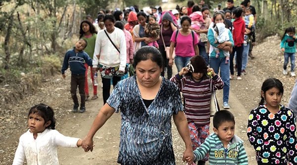 Mehrere Frauen und Kinder laufen auf einer Straße