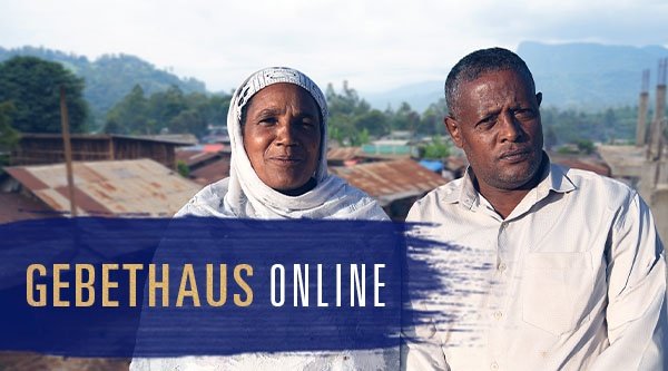 Ein Mann und eine Frau stehen vor einem Dorf