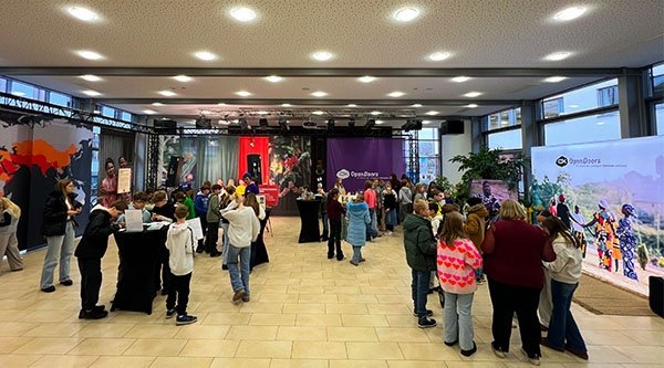 Mehrere Kinder und einige Erwachsene stehen an Open Doors Ständen verteilt