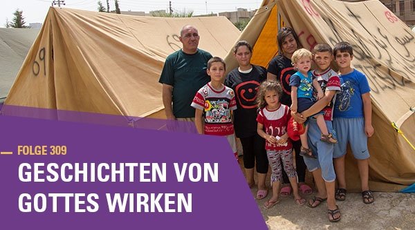 Eine Familie mit sechs Kindern steht vor einigen Zelten