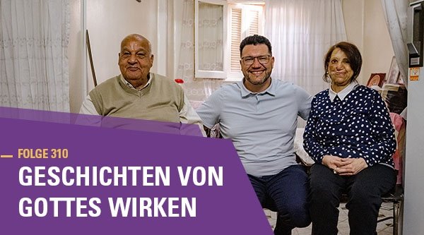 Zwei Männer und eine Frau sitzen vor der Kamera und lächeln