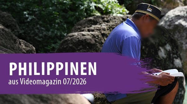 Ein Mann sitzt auf einem Stein und liest ein Buch