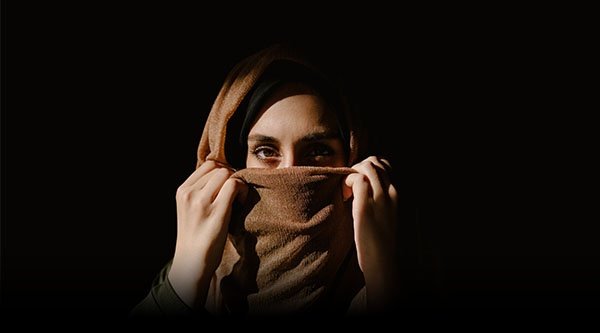 Eine verschleierte Frau blickt in die Kamera