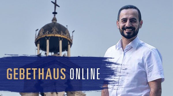 Ein Mann steht vor einer Kirche und lächelt
