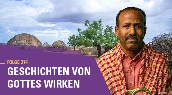 Ein Mann steht vor einem afrikanischen Dorf