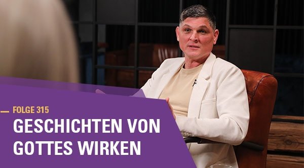 Ein Mann sitzt auf einem Sessel und spricht mit jemandem