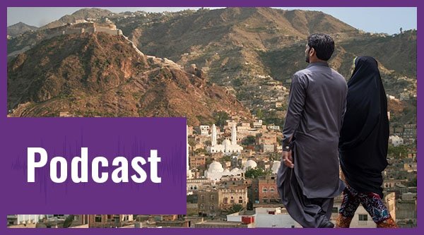 Podcast | Ein Mann und eine Frau laufen vor der Silhouette einer Stadt im Jemen