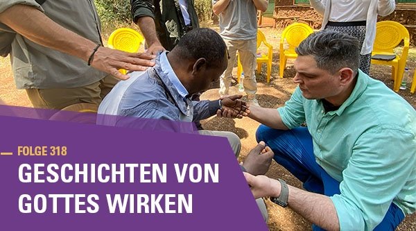 Menschen stehen gemeinsam um einen Mann und beten für ihn.