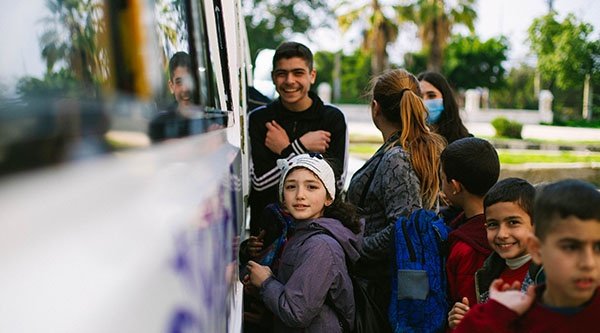 Junge Menschen stehen neben einem Bus