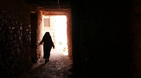 Eine Frau läuft aus einem dunklen Raum nach draußen ins Freie
