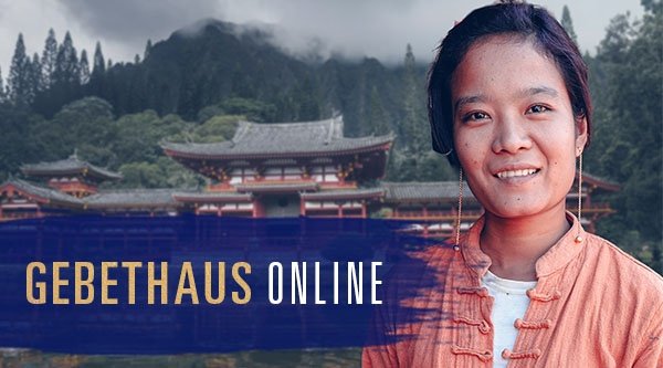 Eine Frau aus dem asiatischem Raum steht vor einem Tempel in den bergigen Wäldern.