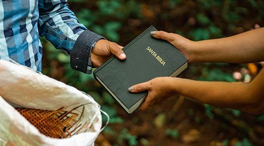 Eine Bibel wird an eine Person weitergereicht