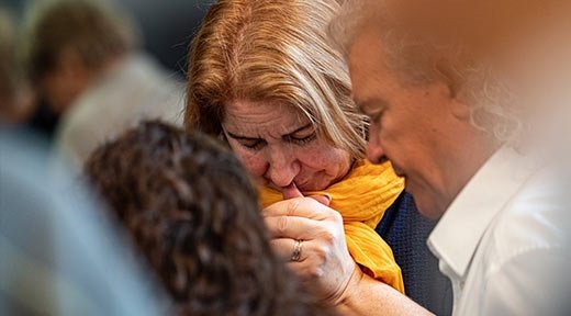 Eine Frau und ein Mann beten in einer Gebetsgruppe für verfolgte Christen
