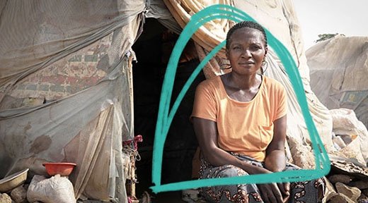 Eine Frau aus Subsahara-Afrika sitzt vor ihrem provisorischen Zelt eines Flüchtlingscamps.