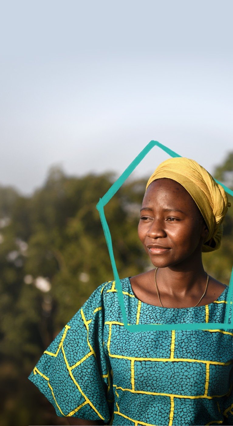 Eine afrikanische Frau steht im Freien vor einigen Bäumen