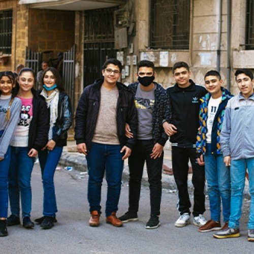 Jugendliche aus Syrien stehen vor Gebäude